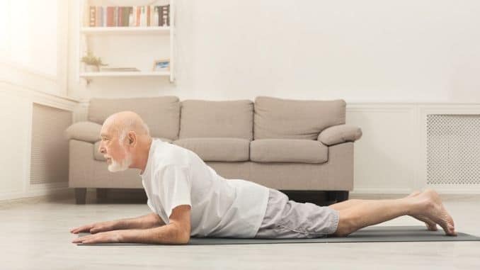 Senior man training yoga in cobra