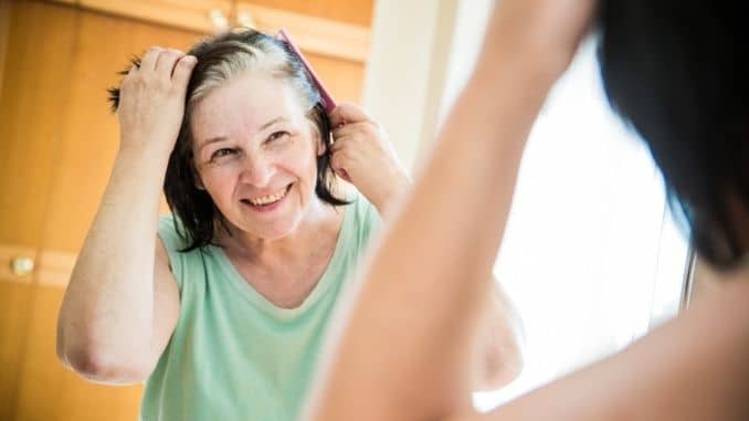 checking her gray hair roots